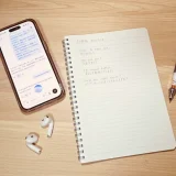 ChatGPT英会話を試したときの机上写真。スマホ、英語練習ノート、イヤホン、ペンを並べている。